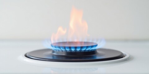 Close-up view of a single gas burner with a blue and orange flame ignited on a white stovetop