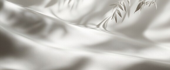 Obraz premium Soft, flowing white fabric with delicate leaf shadows.