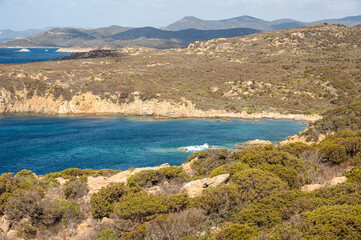 Landscape of the south-west coast of Sardinia with cliffs, blue sea, fjords and white clouds