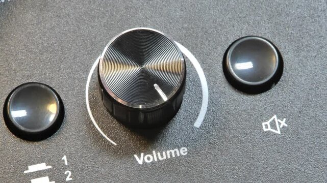 Hand adjusting volume knob to maximum, close-up of audio control, turning sound dial to max, increasing speaker volume, adjusting amplifier knob, sound system control, stereo tuning, music volume up