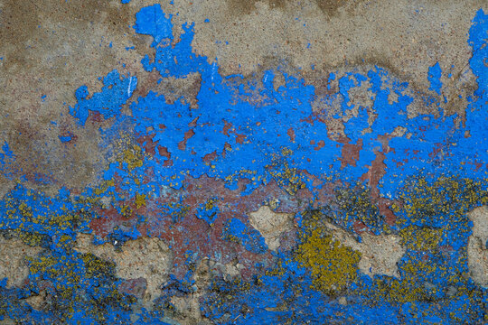 Scraps of blue flacking paint on old wall
