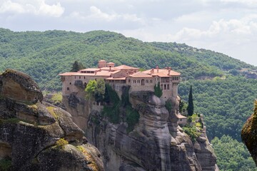 Fototapeta premium Meteora monasteries on the top of a mountain in the morning fog in Kalambaka Greece.