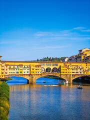 Obraz premium Ponte Vecchio bridge over Arno River in Florence. Picturesque medieval arched river bridge with Roman origins, lined with jewelry and souvenir shops.
