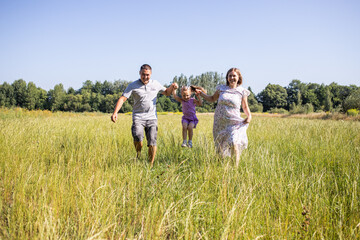 Parent and child. Happy family. Mom, dad and child relaxing in nature. Family in the park. Family having fun. Daughter