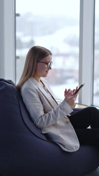 Office business lady smartphone working. Beautiful young business wonan working with phone. Vertical video