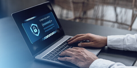Cybersecurity login screen on a laptop with hands typing.