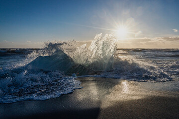 Waves crash onto the shore at sunset, creating a stunning display of nature's beauty and power by...