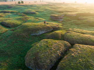 A person with a husky dog on a karst landscape background (drone view).