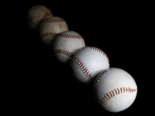 Diagonal row of five baseballs seen from above isolated on black background