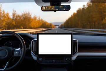 A white blank mock-up touchscreen in a modern car with a minimalist interior driving on the highway