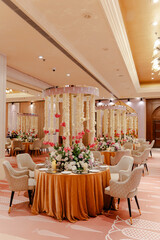 Elegant wedding reception decor with floral arrangements and draped garlands, creating a luxurious and romantic ambiance.