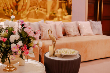 Elegant living room decor with soft cushions, delicate flowers, and decorative bird figurine.
