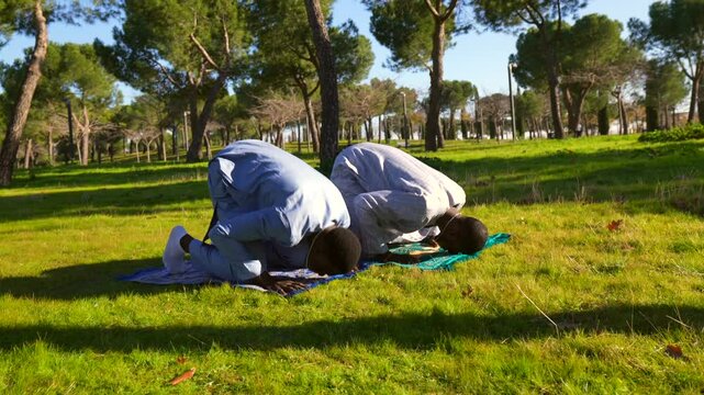 Senegalese muslim men praying in park during ramadan