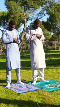 Senegalese muslims performing salat prayer in park