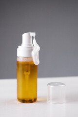 Golden liquid in a transparent container with pump dispenser on a clean surface