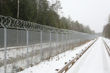 State border - metal fence with a patrol path nearby