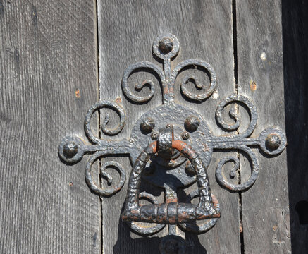 Old iron ornate door knocker on a wooden door of the Salisbury Cathedral, Salisbury, Wiltshire, England, UK. - Powered by Adobe