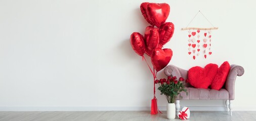 Stylish armchair with heart-shaped cushions, balloons, roses and gift for Valentine's Day. Banner...