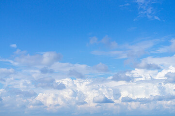 White fluffy clouds, sun and blue sky. Majestic view in summer.
