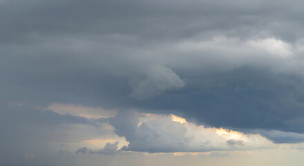 Obraz premium Dark clouds before a thunderstorm with a ray of light. Dramatic sky.