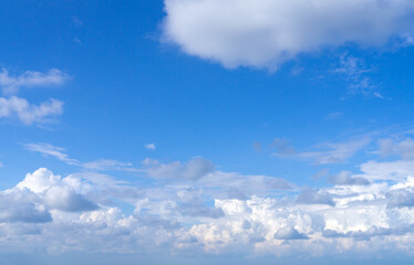 White fluffy clouds, sun and blue sky. Majestic view in summer.