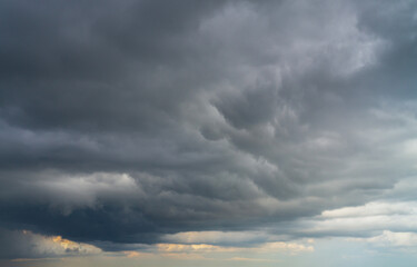 Dark clouds before a thunderstorm with a ray of light. Dramatic sky.