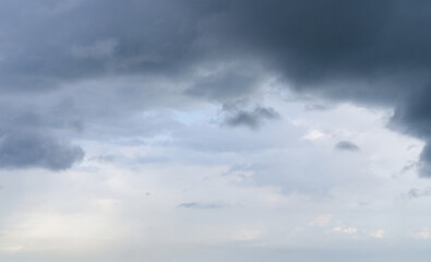 Dark clouds before a thunderstorm with a ray of light. Dramatic sky.