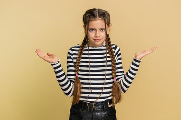 What. Why. Young school girl raising hands in indignant expression asking why what reason of failure, demonstrating disbelief irritation by troubles. Preteen child kid 10 years old on beige background