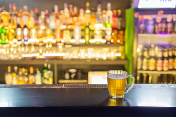 A mug of beer on the bar counter in a pub.