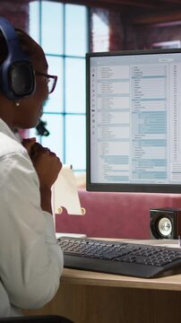 Vertical video Cheerful software developer at computer waiting for code to finish compiling, celebrating after managing to make it run without errors. Woman happy after finishing work on algorithm