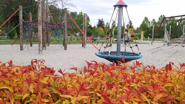 Vibrant playground scene with spinning carousel amidst autumn foliage
