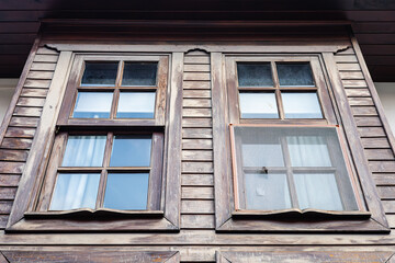 Rustic wooden house windows with weathered texture and reflections