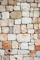 Textured stone wall with varied colored bricks in a rustic pattern