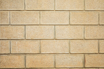 Textured beige brick wall pattern with horizontal staggered layout