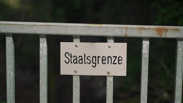 Schilder Grenze zwischen Deutschland und Oesterreich. Tafel Staatsgrenze. Politische Grenze. Schild Grenzlinie zwischen Staatsgebieten. Fence sign State border in Germany. Border inscription in German