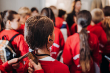 Group of kids children on excursion in a museum gallery, school pupils and students tour with guide, a docent with a tourists, young visitors wearing red, school field trip, art exhibition attendees