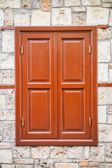 Closed wooden window on stone wall with rustic charm