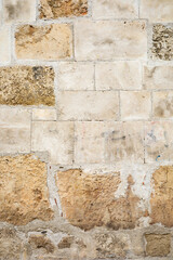 Textured stone wall with varied beige and brown tones