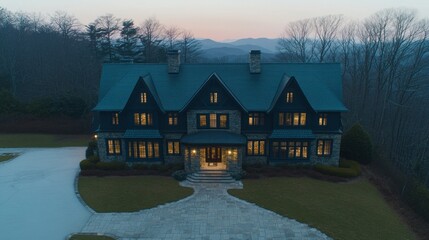 Luxurious mountaintop home at dusk, aerial view.