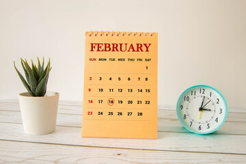 Cube shape calendar for February 18 on wooden surface with empty space for text.