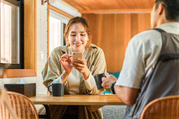 家・別荘・コテージでスマホを見ながらコーヒーを飲む夫婦・カップル・男女(話す・会話)
