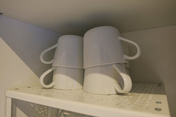 Coffee cups in a white cabinet