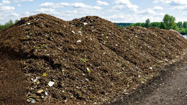Large piles of organic materials for composting at a rural site during a sunny day