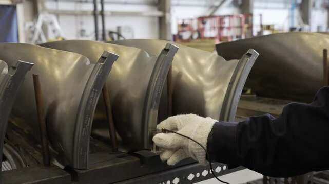 Ultrasonic inspection being performed on dovetail portion of airplane turbine engine fan blades.