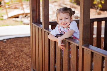Obraz premium Happy preschool girl smiling in cubby house at kindergarten