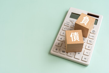 負債の文字が書かれたブロックと電卓