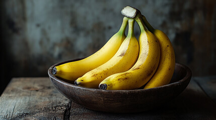 Fresh yellow bananas in a wooden bowl on rustic table with natural lighting