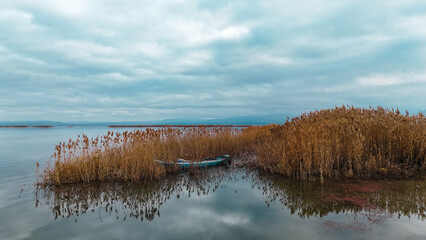 A blue fishing boat lost among the dried yellow reeds in the middle of Suğla lake