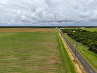 Aerial View of Rural Farmland with a Straight Road and Overcast Sky  