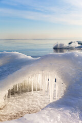 Obraz premium Lake Baikal on January morning. During the freeze-up, the shore is covered with white ice floes with arches and icicles, called sokuy. Beautiful landscape of freezing lake. Winter natural background